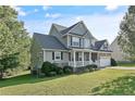 Two story house with gray siding, stone accents, and a covered front porch at 157 Regimental Dr, Cameron, NC 28326