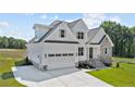 Two-story home with white siding, stone accents, and a two-car garage at 125 Cotton Fields Ln # 26, Fuquay Varina, NC 27526