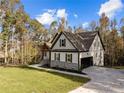 Craftsman style home with stone accents and a two-car garage, nestled on a wooded lot at 143 Hook Dr, Fuquay Varina, NC 27526