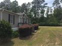 Single-wide mobile home with brown siding and landscaping at 4191 Swanns Station Rd, Sanford, NC 27332