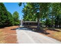 Long driveway leading to a charming home with a covered porch and trees at 6663 Nc 56 Hwy, Franklinton, NC 27525