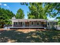 Inviting home with a covered porch, large front yard, and mature trees at 6663 Nc 56 Hwy, Franklinton, NC 27525