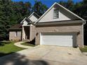 Brick house with a white garage door and landscaping at 1977 Putters Cir, Sanford, NC 27332