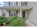 Front porch with stone detailing, black door, and lush landscaping at 72 New London Hbr, Cameron, NC 28326