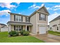 Tan two-story house with black window frames, a two-car garage, and a well-maintained lawn at 72 New London Hbr, Cameron, NC 28326