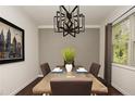 Dining room with a rustic table, modern chandelier, and gray accent wall at 573 Solomon Dr, Cameron, TN 38326