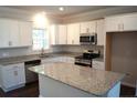 Modern kitchen with white cabinets, granite counters, and stainless steel appliances at 124 Knotts Berry Rd, Bunnlevel, NC 28323