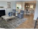 Open living room with hardwood floors, a fireplace, and views into the kitchen and dining area at 241 Bunting Dr, Lillington, NC 27546