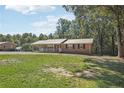 Brick ranch house with covered porch and large yard at 1136 Pumping Station Rd, Sanford, NC 27330