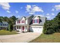 Two story house with red shutters and a two car garage at 66 Great Oak Ct, Bunnlevel, NC 28323