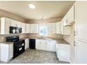 Modern kitchen featuring white cabinets, granite countertops, and black appliances at 15 Red Bird Dr, Cameron, NC 28326