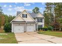 Two-story house with a three-car garage and landscaped yard at 58 Shortleaf Ct, Cameron, NC 28326