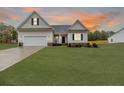 Beige house with a sunset in the background at 24 Black Oak Pl, Spring Lake, NC 28390