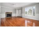 Living room with hardwood floors, fireplace, and wainscoting at 8037 Perry Creek Rd, Raleigh, NC 27616