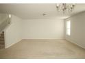 Spacious living room with neutral carpet, chandelier, and staircase at 299 Hallow Oak St, Spring Lake, NC 28390