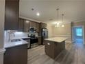 Modern kitchen with island, stainless steel appliances, and granite countertops at 260 Gallery Dr # 101, Spring Lake, NC 28390