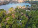 Aerial view of a lakefront property with houses surrounded by trees at 1374 Pennsylvania Ave, Sanford, NC 27332