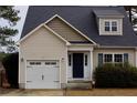 Beige two-story house with a white garage door and dark blue front door at 696 Valley Oak Dr, Bunnlevel, NC 28323