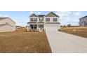 Two-story house with gray siding, stone accents, and a two-car garage at 38 Steeple Ridge (Lot 597), Cameron, NC 28326