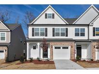 Two-story home with brick and white siding, a two car garage, and landscaping at 333 Marbella Grove Ct, Durham, NC 27713