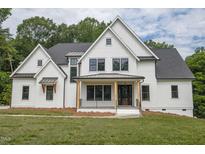 White two-story farmhouse with gray roof and black accents at 13629 Old Creedmoor Rd, Wake Forest, NC 27587