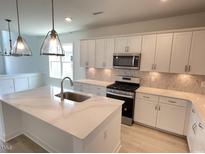 Modern kitchen with island and white cabinets at 112 Swain St, Clayton, NC 27527
