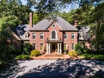 Brick house with a large porch and columns, showcasing its classic architecture at 2441 W Lake Dr, Raleigh, NC 27609
