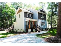 Two-story house with gray and brown siding, front porch, and stairs at 7647 Cummings Dr, Mebane, NC 27302