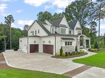 Two-story home with white brick, dark roof, and landscaping at 1621 Legacy Ridge Ln, Wake Forest, NC 27587