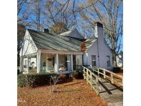 Charming white home with a sunroom, wooden ramp, and landscaping at 1852 Nc 62 Hwy N, Burlington, NC 27217