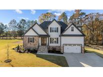 Two-story house with stone and white siding, a two-car garage, and landscaping at 148 Hook Dr # 7, Fuquay Varina, NC 27526