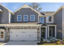 Exterior view of a two-story townhome with gray siding and a stone facade at 2321 Sugar Cone Way, Fuquay Varina, NC 27526