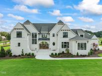 Two-story white brick home with gray roof and landscaping at 8916 Grand Highland Way, Wake Forest, NC 27587