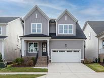 Charming two-story home with a gray exterior, white trim, and attached garage at 1721 Grassy Falls Ln, Wendell, NC 27591