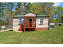 One-story home with green roof, wooden deck, and lawn at 221 Stroud St, Sanford, NC 27330