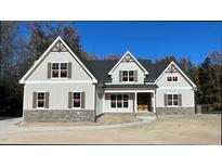 Two-story house with gray siding, stone accents, and a large front porch at 120 Old Garden Ln, Youngsville, NC 27596