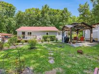 Backyard with two houses, deck, gazebo, and lush landscaping at 2620 Alston Chapel Rd, Pittsboro, NC 27312