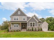 Two story home with gray siding, stone accents, and a welcoming front porch at 242 Lakestone Estates, Pittsboro, NC 27312