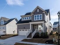 Charming two-story home with a gray exterior, white trim, and a welcoming front porch at 1713 Grassy Falls Ln, Wendell, NC 27591