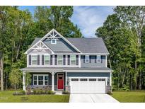 Two-story gray house with a red door and white garage at 8808 Tartan Clan Dr, Willow Springs, NC 27592