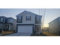 Two-story home with gray and beige siding, a white garage door, and landscaping at 2728 Princess Tree Dr, Raleigh, NC 27616