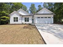 White farmhouse style home with two car garage at 242 Sequoia Dr, Louisburg, NC 27549