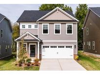 Two-story home with gray siding, white garage door and landscaping at 81 Hank Way, Angier, NC 27501