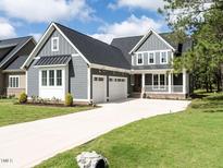 Gray two-story farmhouse with a two-car garage at 1000 Azalea Garden Circle, Raleigh, NC 27603