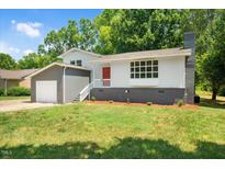 Ranch home with gray and white exterior, red door and attached garage at 1844 Brier Ln, Graham, NC 27253