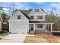 Charming two-story home with a welcoming front porch and a two-car garage at 112 Pointe Park Cir # 96, Holly Springs, NC 27540