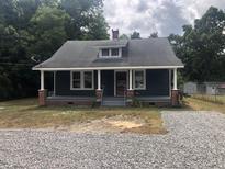 Charming one-story home with a spacious front porch and gravel driveway at 3124 Raleigh Rd, Henderson, NC 27537