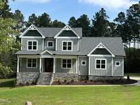 Two-story home with gray siding and stone accents at 200 Whistlers Cv, Louisburg, NC 27549