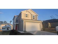 Two-story house with gray siding, red door, and a two-car garage at 2709 Princess Tree Dr, Raleigh, NC 27616