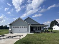 Two-car garage house with gray siding and landscaped lawn at 78 Grace Ridge Ct, Benson, NC 27504